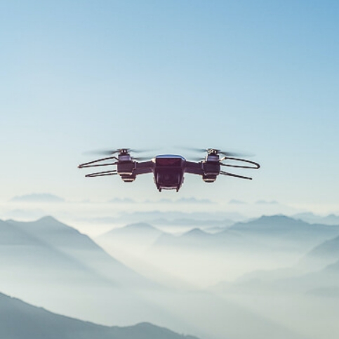 Drone en vol capturant une vue panoramique d'une montagne enveloppée de brume.